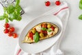 Italian traditional dish with eggplant, tomatoes, olives, mozzarella and basil. Baked aubergine stuffed with vegetables on a white Royalty Free Stock Photo