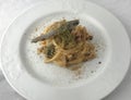 Italian Traditional DishSpaghetti con le sardeon plate with white table background.