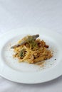 Italian Traditional DishSpaghetti con le sardeon plate with white table background.