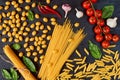 Italian traditional food, spices and ingredients for cooking as basil, cherry tomatoes, chili pepper, garlic and various pasta Royalty Free Stock Photo