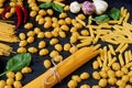 Italian traditional food, spices and ingredients for cooking as basil, chili pepper, garlic and various pasta on black background Royalty Free Stock Photo