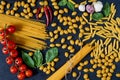 Italian traditional food, spices and ingredients for cooking as basil leaves, cherry tomatoes, chili pepper, garlic, various pasta Royalty Free Stock Photo