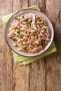 Italian traditional salad with tuna, onions and white beans close-up in a plate. vertical top view Royalty Free Stock Photo