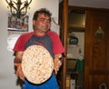 Italian traditions baker shows and throws round just cooked pizza bread