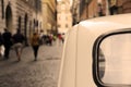 An italian vintage car parked in the streets of Rome, a nun walking on the background. Royalty Free Stock Photo