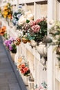 Italian wall cemetery with tombstones and artificial flowers on a sunny summer day in Venice, Italy, Island of San Michele.