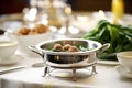 italian wedding soup with meatballs and spinach, in a silver tureen, ladle beside
