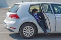 An italian woman open the car door, ready to get out. Lady wears face mask for covid19, rules after reopening in Europe.