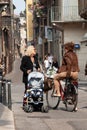 Italian women with baby stroller and bicycle on city streets