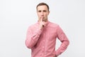 Italian young man in pink shirt doing a silence gesture Royalty Free Stock Photo