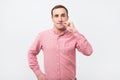 Italian young man in pink shirt doing a silence gesture Royalty Free Stock Photo