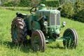 Italy. Antique tractor Orsi in a green field.