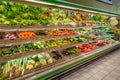 Fresh vegetables in crates and ready-to-eat packages displayed on the refrigerated counter shelves Royalty Free Stock Photo