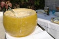Original whole wheel of Italian cheese Grana Padano served in a restaurant in liquid form for spaghetti