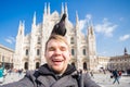 Italy, excursion and travel concept - funny guy taking selfie with pigeons in front of cathedral Duomo in Milan Royalty Free Stock Photo