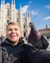 Italy, excursion and travel concept - funny guy taking selfie with pigeons in front of cathedral Duomo in Milan Royalty Free Stock Photo