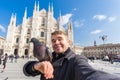 Italy, excursion and travel concept - funny guy taking selfie with pigeons in front of cathedral Duomo in Milan Royalty Free Stock Photo