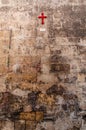 Italy. Matera. A red cross on the wall of an ancient defense tower marks the place where the Porta di Iuso, the door at the bottom