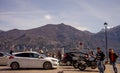 Italy, Menaggio, Lake Como, a group of people standing in a parking lot in front of a mountain