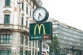 Italy, Milan, May 30, 2019: A street clock and a McCafe sign on the background of urban buildings and houses