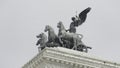 Italy, Rome - July 29, 2022: Statue with horses and man on building. Action. Beautiful composition with statues on roof Royalty Free Stock Photo