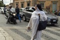 Italy Rome. October 07,2018. A nun in white clothes walking along a pedestrian crossing in the center of Rome, holding a Royalty Free Stock Photo