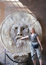 Italy. Rome. Woman tourist puts hand to mouth of truth