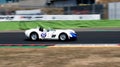 Historical Lister Knobbly 60s race car on racetrack blurred motion background