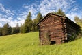 Italy / South Tyrol / Alto Adige / Gadertal:  wodden stall for cows and hay on the alp on bright day with clouds - larch and spruc Royalty Free Stock Photo