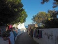 ITALY, STROMBOLI, JUNE 2, 2016: Street leading to port at Stromboli with colorful selling clothes hanging from the surrounding wa