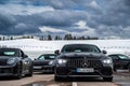 Italy, Trentino, 29 April 2019: The group of luxury sports cars does a stop on the twisting road, snow-covered field on Royalty Free Stock Photo