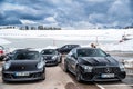 Italy, Trentino, 29 April 2019: The group of luxury sports cars does a stop on the twisting road, snow-covered field on Royalty Free Stock Photo