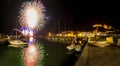 Italy, Tuscany Maremma Castiglione della Pescaia, fireworks over the sea, panoramic night view of the port and the castle Royalty Free Stock Photo