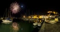 Italy, Tuscany Maremma Castiglione della Pescaia, fireworks over the sea, panoramic night view of the port and the castle Royalty Free Stock Photo