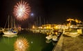 Italy, Tuscany Maremma Castiglione della Pescaia, fireworks over the sea, panoramic night view of the port and the castle Royalty Free Stock Photo