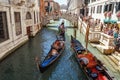 ITALY, VENICE - JULY 2012: Gondolas with tourists cruising a small Venetian canal on July 16, 2012 in Venice. Gondola is a major