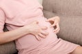 Itching woman is pregnant sitting on sofa at the home Skin problems and pores in teenagers