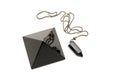 Items of magic from black onyx. Pyramid and pendulum. Isolated white background