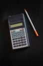 Vintage calculator and pencil. Finds in the attic of an old house. Antique things. Dark background. Vertical layout. Royalty Free Stock Photo