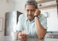 Itll get better with time. a senior man looking unhappy while looking at a photo at home. Royalty Free Stock Photo