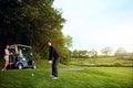 Its all about focus and precision. a man playing a round of golf with his friends. Royalty Free Stock Photo