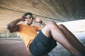 Its all a matter of mind over muscle. a young man doing sit ups against an urban background.