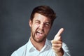 Its all you. Studio portrait of a handsome young man making a face against a dark background. Royalty Free Stock Photo