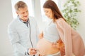 Joyful pregnant woman having a survey and looking at stomach.