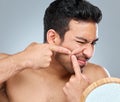 Its a bad habit but I cant stand pimples. a young man squeezing a pimple on his face. Royalty Free Stock Photo