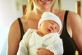 Its bedtime for this little one. a tired little baby boy sleeping with his eyes closed while his mother holds him in her Royalty Free Stock Photo