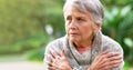 Its a bit cold today. a carefree elderly woman seated on a bench while contemplating outside in a park. Royalty Free Stock Photo