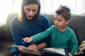 Its a book filled with a surprise at every turn. a mother reading a book to her little son at home. Royalty Free Stock Photo