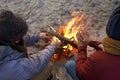 Its cold this morning. Two young men sitting around a fire on the beach. Royalty Free Stock Photo