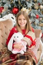 Its so cuddly and soft. Small child happy smiling with presents. Little girl with cute bunny at Christmas tree. Small Royalty Free Stock Photo